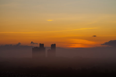 Golden sunrise near the silhouette of the skyscraper building.の写真素材