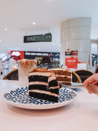 putrajaya, Malaysia - June 8, 2022 Red velvet and carrot cakes on the table with iced latte for tea time in  IOI City Mall.のeditorial素材