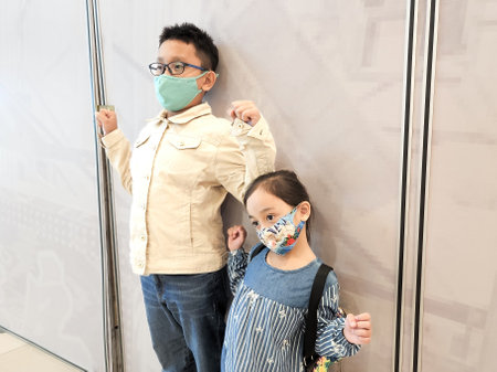 Half body size view of attractive cheerful kids wearing face masks over white background.の写真素材
