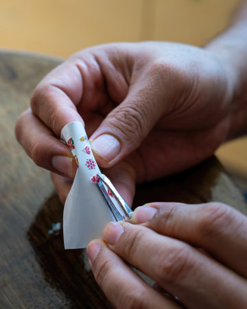 Taking out a nail sticker from the sheet to apply on nails.の写真素材