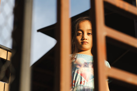 Sad little girl standing in outdoor. Low angle view.の写真素材