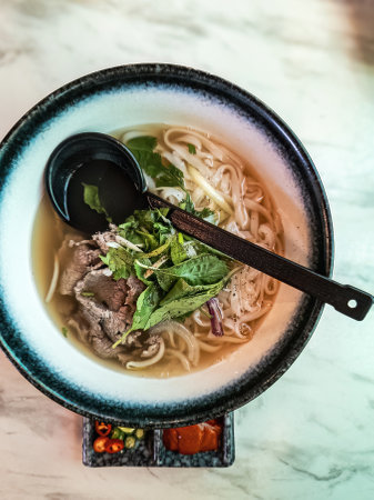 Top view of Vietnamese style noodle served with large spoon.