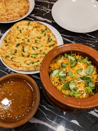 Claypot biryani rice served with flat bread Naan served on the table.の写真素材