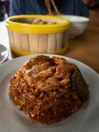 Glutinous rice with soy sauce cooked together with chicken parts and eat with chop stick.の写真素材