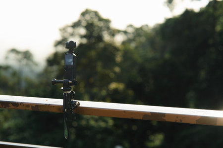 Gimbal camera on tripod attached to the metal bar, capturing time-lapsed video.の写真素材