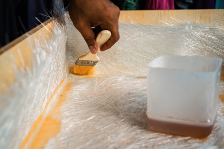 Brushing solution through fiberglass sheets on a wooden box. A diy project at home.の写真素材