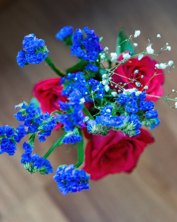 Top view of fresh blue baby breath with roses on a wooden background.の写真素材