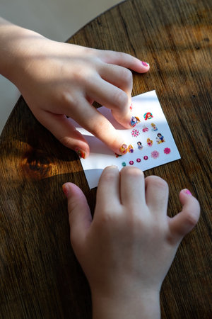 Bangi, Malaysia - July 17, 2021 Choosing a nail sticker from the sheet to apply on nails.のeditorial素材