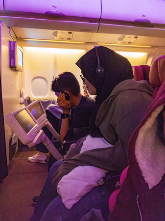 Muslim passenger wearing hijab is watching movies on the airplane.の写真素材