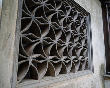 Black and white photo of a vintage concrete ventilation block wall with repetitive square openings, creating a strong geometric pattern and retro architectural texture.の写真素材