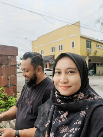 Middle aged woman taking selfie with husband looking down in outdoor.の写真素材