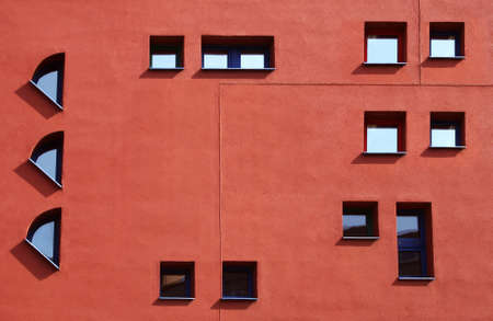 Facade with small atypical windows on the facade of brick color.の写真素材