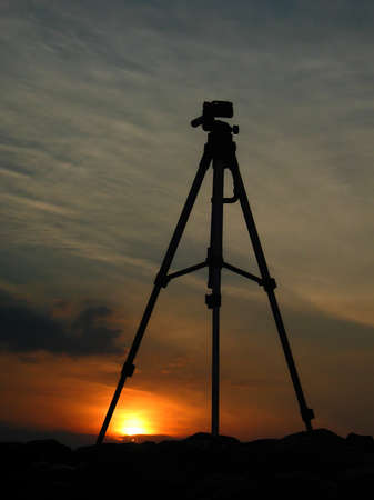 Silhouette of a tripod on top of a basalt mountain. Scenery with silhouettes over the valley at...