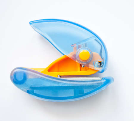 Small puncher, one-hole clear yellow-blue hand tool. Two-color plastic office tool suitable for...