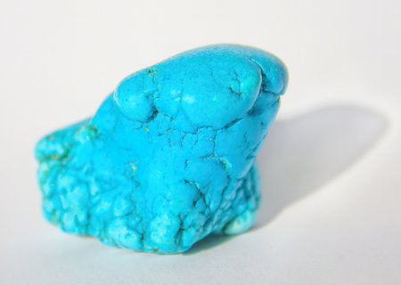White background with mineral, natural healing raw turquoise stone. One natural turquoise stone with...