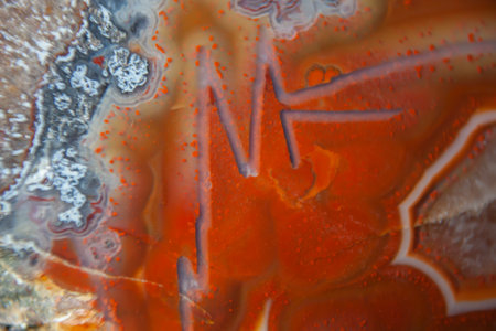 Microscopic detail of raw agate. Natural background. Orange semi-precious stone orange agate with a...