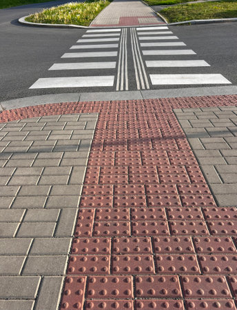 The way on the street. Marked barrier-free transition. Urban paved sidewalk and roadway with...