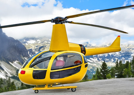 Yellow helicopter in high mountains. Rescue helicopter in inaccessible mountain places, mountain rescue. Background with a view of snowy mountains.の写真素材