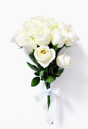 Fresh bouquet of white roses. Flowers tied with a white ribbon on a white background.の写真素材