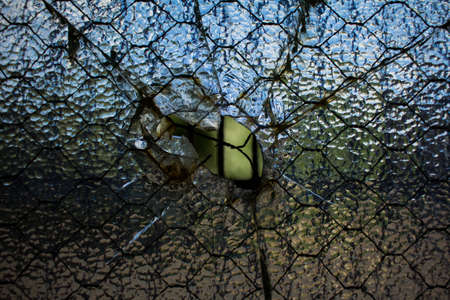 A window with a hole smashed in the middle