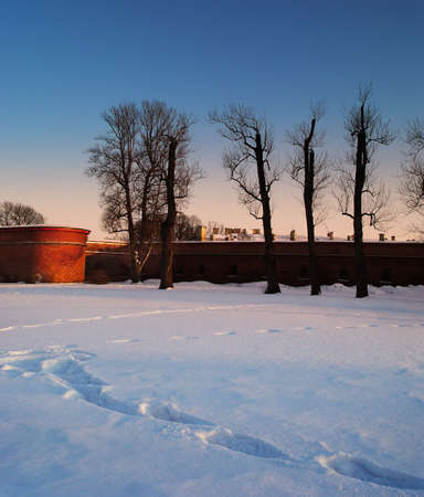 Wall of the ancient fortress at sunset in dead of winterの写真素材
