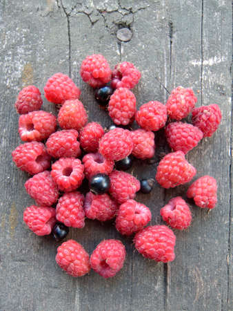 Small group of raspberries and black-currant on the old planking