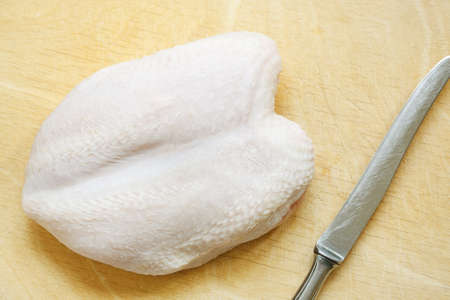 Fresh chicken breast on a wooden cutting boardの写真素材