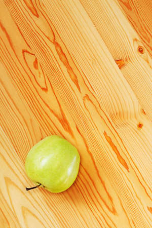 One green apple on smooth boards. View from the topの写真素材