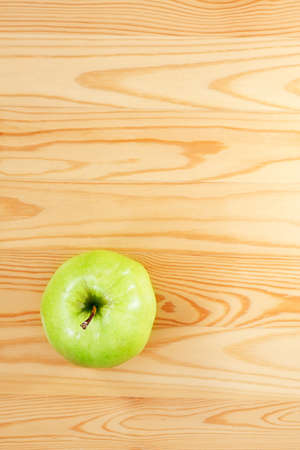 Green apple on a light wood  View from the topの写真素材