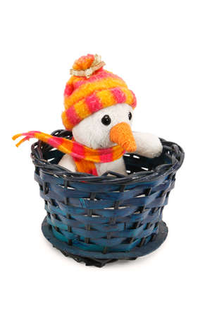 Toy snowman sitting in a wicker basket isolated on white backgroundの写真素材
