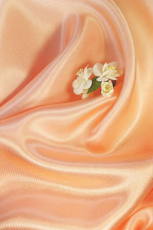 Artificial flowers of jasmine on warm sunny satinの写真素材