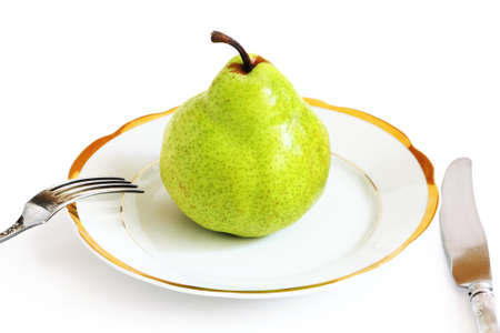 Big green pear on a white plate isolated on white backgroundの写真素材