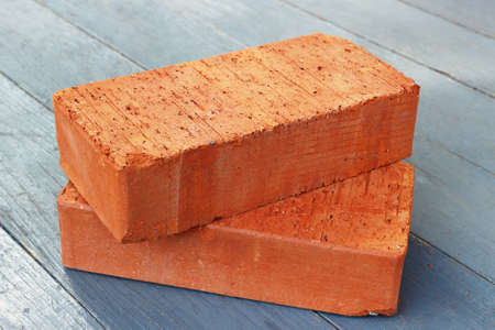 Two red bricks on wooden floor