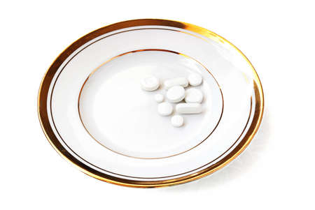 White pills on a white china isolated on a white backgroundの写真素材