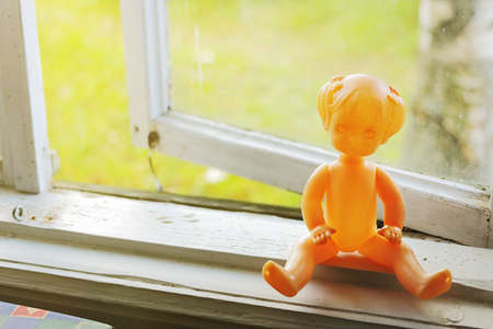 Vintage plastic doll on the window sill.  Mass production, 1970の写真素材