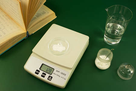 Substance weighing, graduated glass and reference bookの写真素材