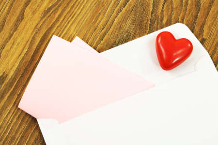 Open envelope with the red heart and a pink paper for your text