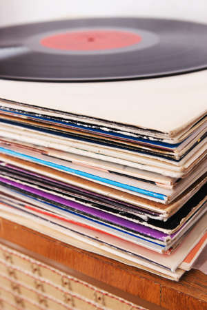 Pile of the vinyl records on the vintage radio player