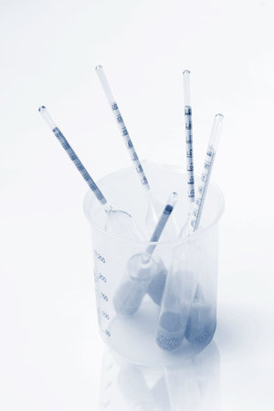 Several old glass float hydrometers in empty plastic chemical beaker