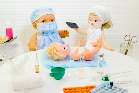 Toy doctor and doll nurse under treatment of sick little dollの写真素材