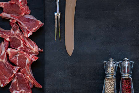 Raw fresh Lamb Meat ribs and seasonings on dark backgroundの写真素材