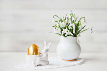 Close-up of beautiful spring decoration with white bouquet of snowdrops flowers and Easter bunny...