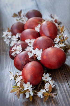 Easter decoration â€“ colored eggs and spring cherry flowers. Close up, selective focus on dark...