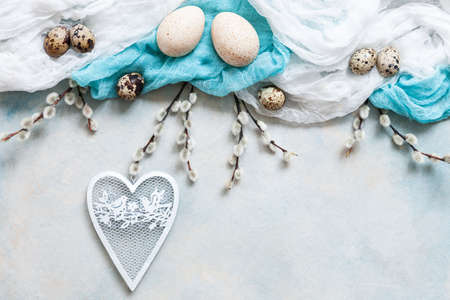 Easter decoration - natural eggs, white heart shape figurine and pussy willow.Top view, close up,...