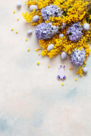 Easter decoration with Easter eggs, mimosa and hyacinths. Top view, close up, flat lay on sky blue backgroundの写真素材