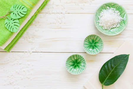 Green plant leaf, aromatic sea salt and towels. Concept for spa, beauty and health salons. Close up...