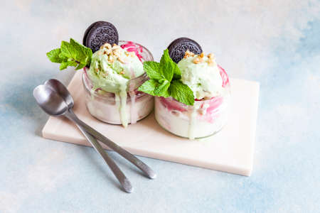  Two Tasty homemade multicolored popsicles ice cream with mint and chocolate cookies leaves in a...