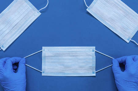 Hands in medical gloves hold Hygienic mask, Surgical mask for protect against COVID-19 Coronavirus