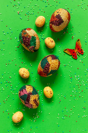 Multicolored eggs and varied easter decoration on green paper backgroundの写真素材