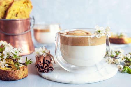 Cup of Trendy whipped cream cold dalgona coffee and Italian biscotti on light grey background.